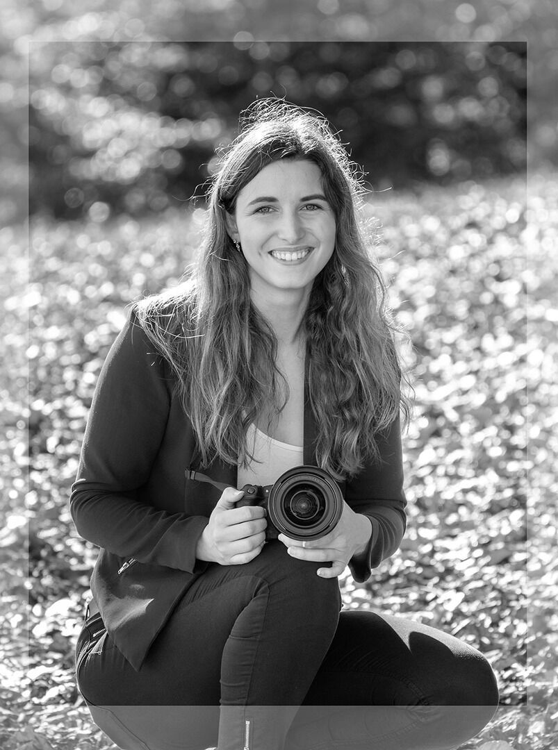 Selina, professionelle Hochzeitsfotografin, mit Kamera in der Hand, bereit für ein Fotoshooting